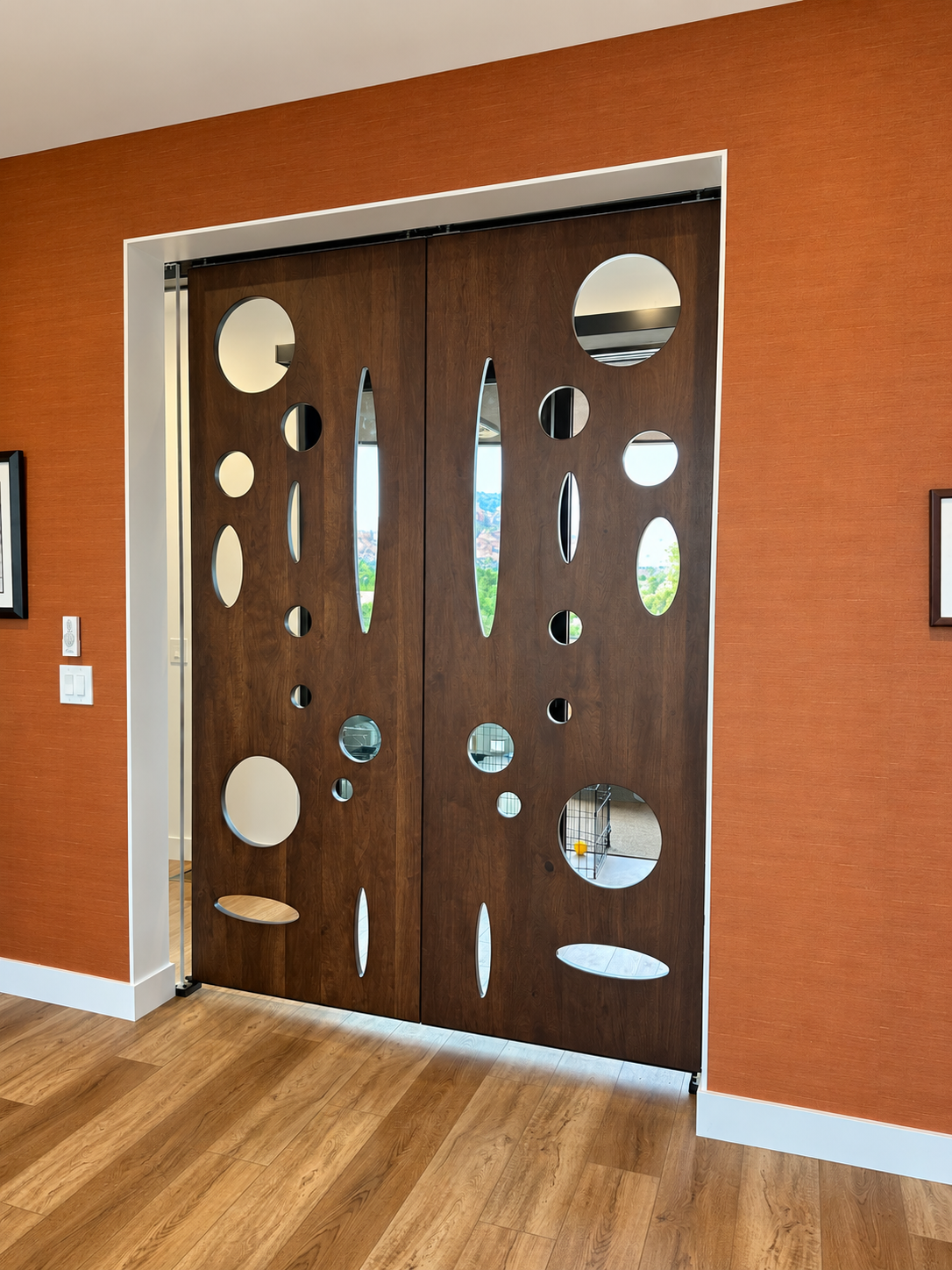 Installed dark wood double doors with circular and elliptical openings